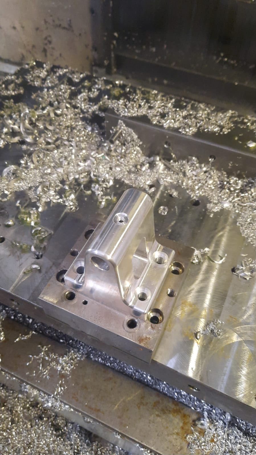 Suporte de motor usinado em bloco maciço de alumínio dentro da máquina CNC